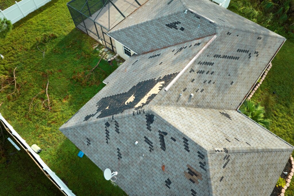 Damaged roof with missing shingles, showing need for roof repairs.